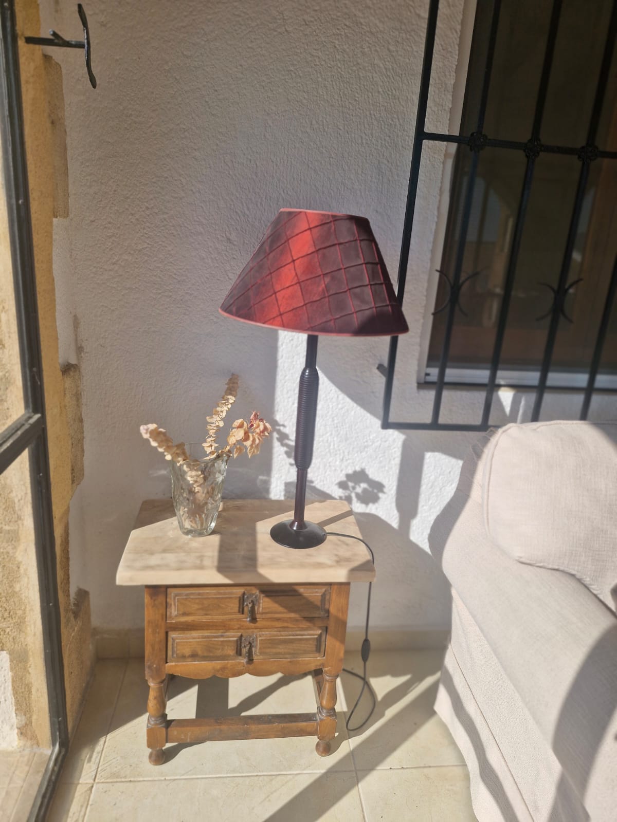Lamp on rustic side table by terrace
